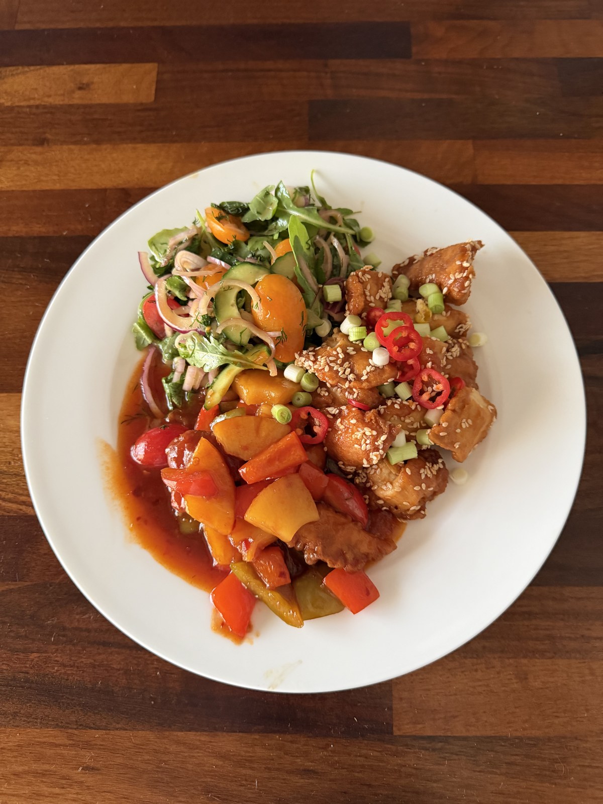 Crispy sweet chilli chicken with peppers, sesame and spring onion, served with a fresh salad